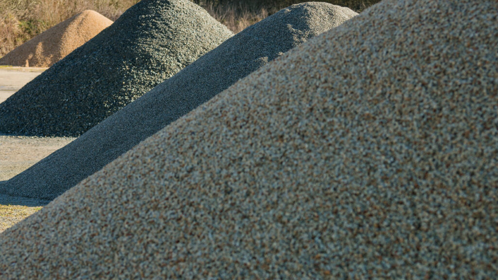 Materiallager Schotter und Splitt als kegelförmige Haufen